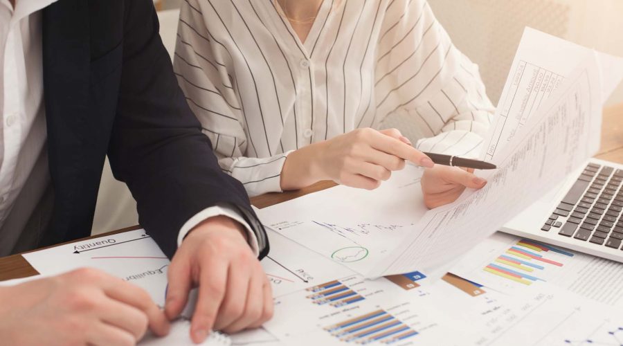 Business colleagues writing notes and checking documents
